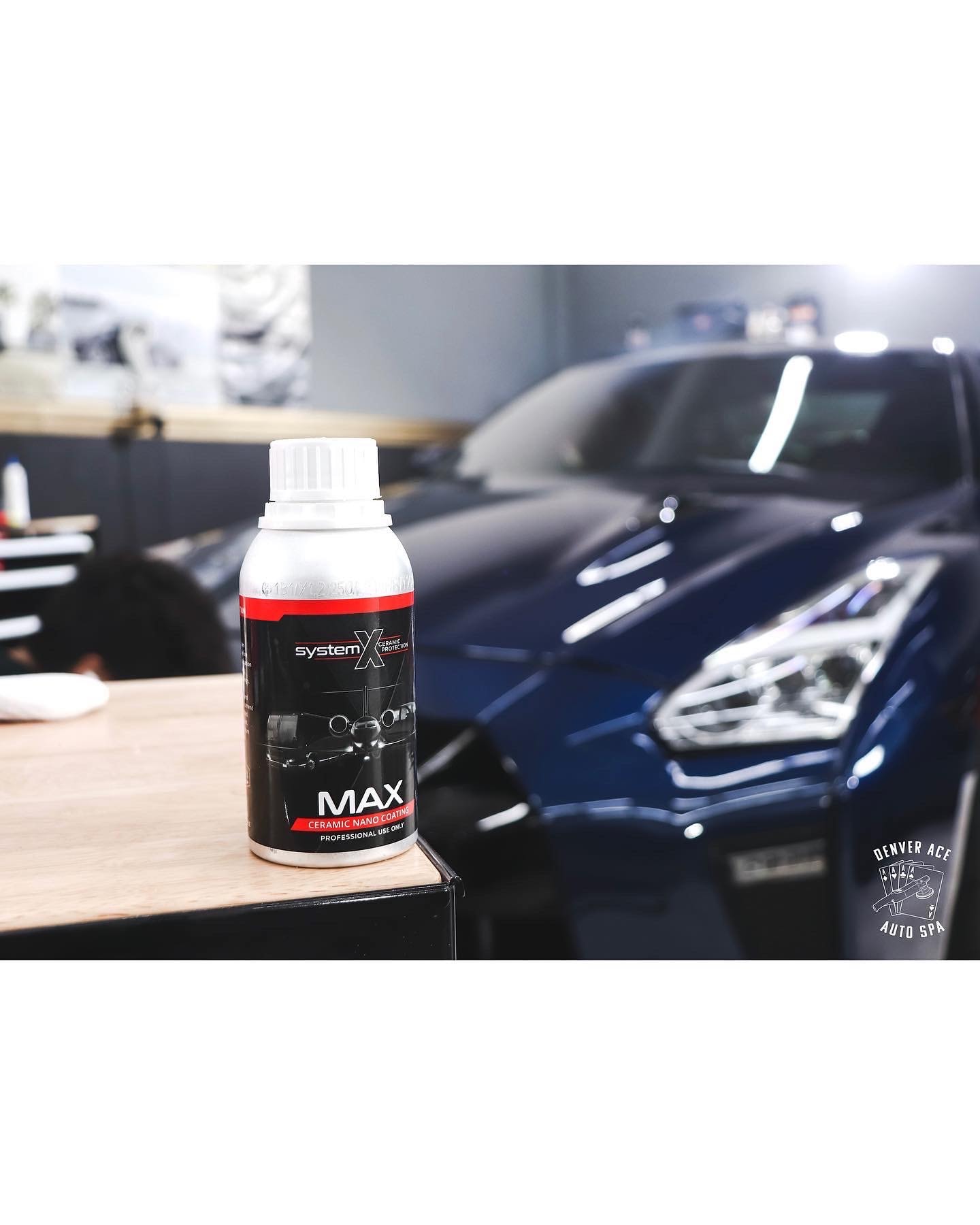 System X ceramic nano coating bottle in front of a blue GT-R at Denver Ace Auto Spa